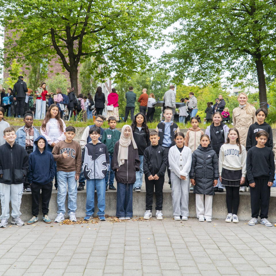 Die neue Klasse 5a steht gemeinsam mit ihrem Klassenteam für ein Gruppenfoto auf dem Schulgelände.