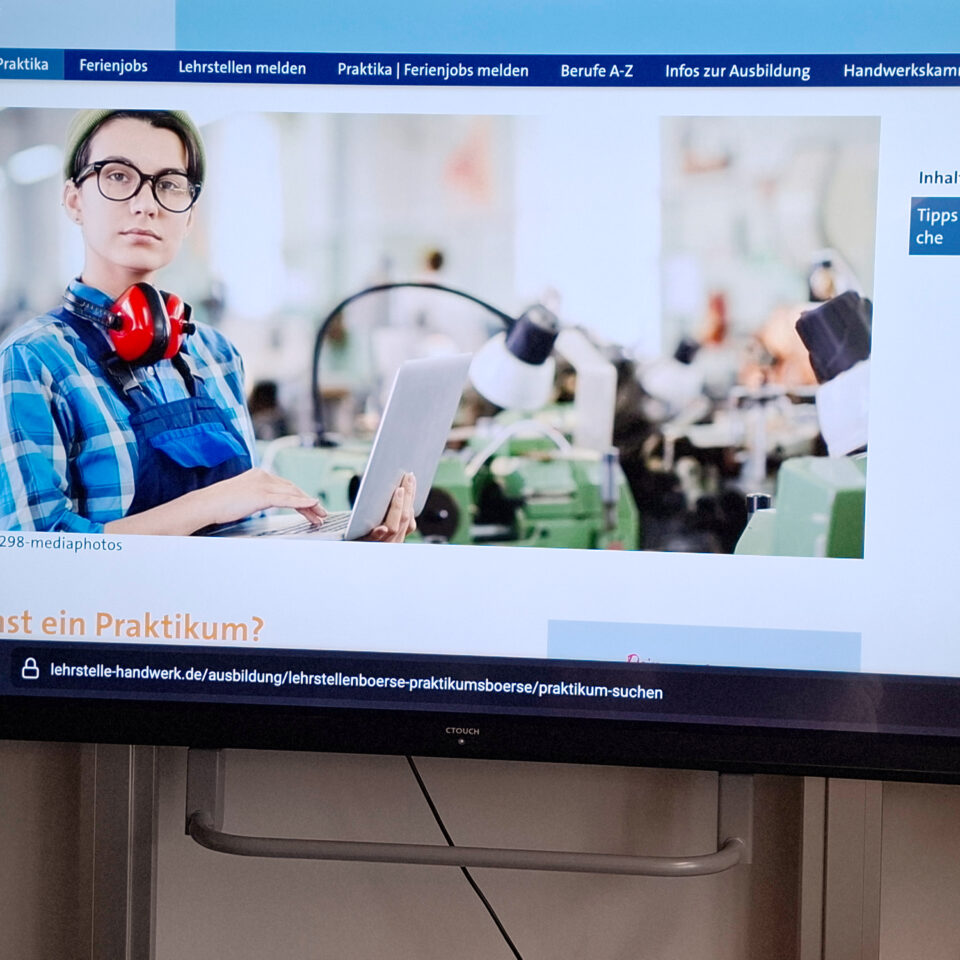 Auf einem Bildschirm ist die Internetseite der Handwerkskammer Hamburg zur Praktikumssuche geöffnet. Im oberen Bereich ist ein Bild einer Person in Arbeitskleidung mit einem Tablet zu sehen.