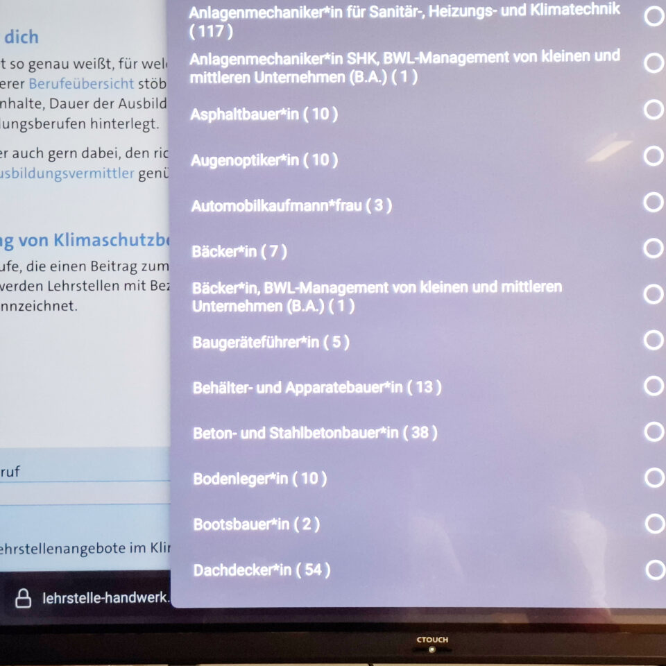 Auf dem Bildschirm ist eine Auswahlliste mit verschiedenen Ausbildungsberufen geöffnet, darunter Anlagenmechaniker:in, Augenoptiker:in, Bäcker:in und Dachdecker:in.