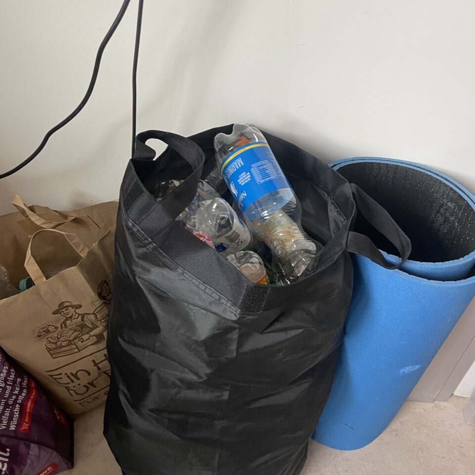 Eine große schwarze Tasche ist mit leeren Pfandflaschen gefüllt, die die Klasse 8a für ihre Spendenaktion gesammelt hat.